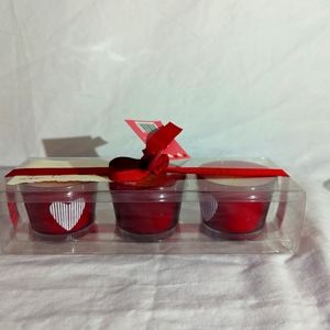 3 red votive candle cups including the candles with a white heart design on each